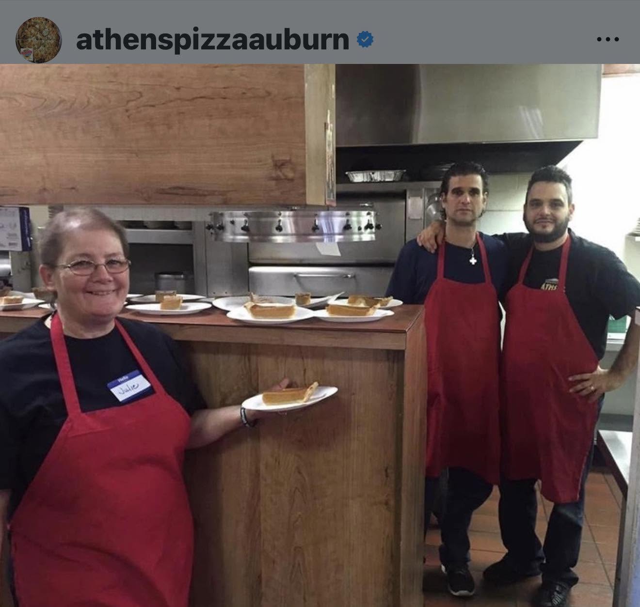 Julie and the Athens Pizza kitchen team in red aprons